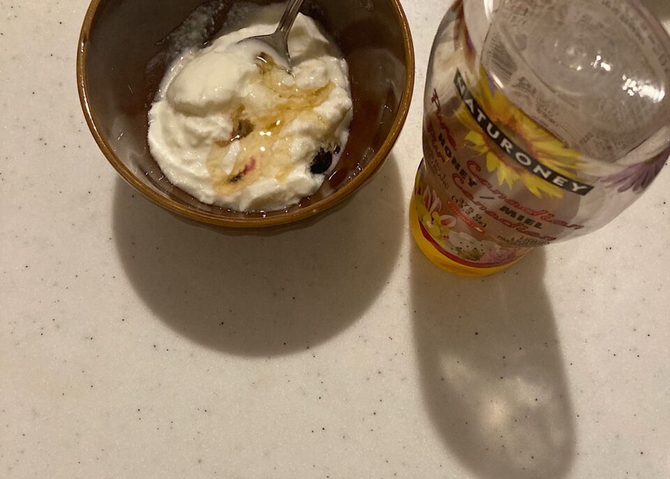 ハチミツ入りのヨーグルトとボトルに入ったハチミツ
